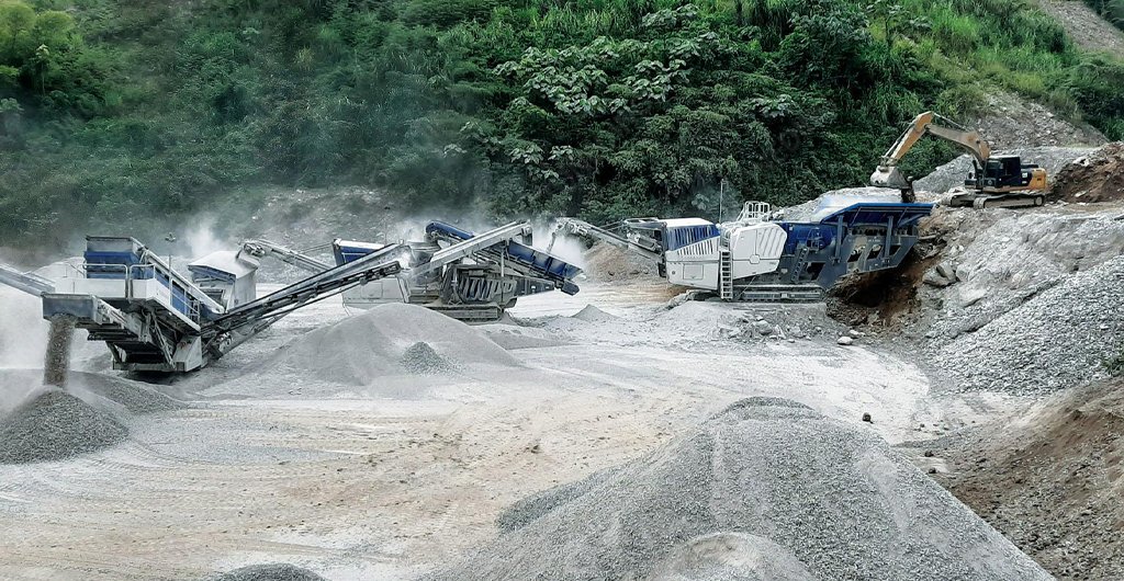 80 TPH limestone road-base plant with mobile crusher, vibrating screen, conveyors, and aggregate stockpiles.